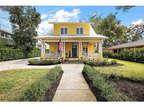 Charming yellow two-story home featuring a welcoming front porch and well-maintained landscaping at 932 N Mcdonald St, Mount Dora, FL 32757