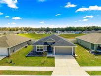 Charming one-story home with a well-manicured lawn and a gray exterior at 10420 E 161St St, Summerfield, FL 34491