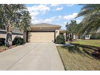 Charming home with a two-car garage, well-maintained lawn, and landscaping at 12497 Se 92Nd Ave, Summerfield, FL 34491