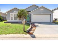 Charming single-story home with well-manicured lawn and a cozy, inviting entrance, plus a turquoise door at 1917 Emily Blvd, Winter Haven, FL 33884