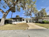 Charming single-story home with a covered carport and a well-maintained front yard, perfect for relaxed living at 206 Aspen Cir, Leesburg, FL 34748