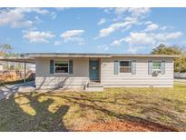 Charming single-story home features a well-maintained lawn, a carport and a welcoming blue front door at 2803 Joleen Dr, Eustis, FL 32726