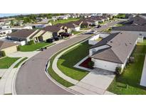 Aerial view of a charming residential neighborhood with well-maintained lawns and sidewalks at 440 Kensington View Dr, Winter Haven, FL 33880