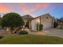 Charming single-story home with well-manicured lawn and attached two-car garage at dusk at 480 Ne 45Th Ter, Ocala, FL 34470