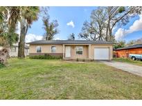 Charming single-story home with a well-maintained lawn, attached garage, and inviting front entrance at 7036 Clarcona Ocoee Dr, Orlando, FL 32818