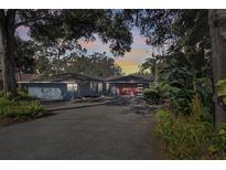 Charming single-story home with lush landscaping, driveway, and a modern garage door at 925 Northside Dr, Mount Dora, FL 32757