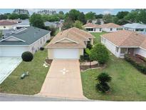 Charming one-story home featuring a well-manicured lawn, inviting driveway, and attached garage at 9481 Sw 93Rd Loop, Ocala, FL 34481