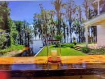 Peaceful view of the lake with a decorative candle on a wooden railing at 12117 Cypress Ln, Clermont, FL 34711