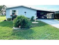 Charming single-story home featuring a well-maintained lawn and covered carport at 1336 E Schwartz Blvd, The Villages, FL 32159