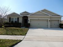 Charming home featuring a three car garage, well-manicured lawn, and neutral tones at 1408 Diamond Loop Dr, Kissimmee, FL 34744