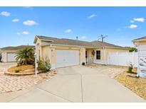 Charming home featuring a well-manicured lawn and a paved driveway leading to an attached two-car garage at 17126 Se 78Th Larchmont Ct, The Villages, FL 32162