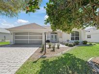 Charming single-story home featuring a well-manicured front yard, attractive landscaping, and a two-car garage at 2039 Palo Alto Ave, The Villages, FL 32159