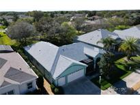 Aerial view of charming single-story home featuring a screened lanai, lush landscaping, and attached two car garage at 25517 Laurel Valley Rd, Leesburg, FL 34748