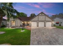 Charming single-Gathering home with a paver driveway, three-car garage and manicured front lawn with palm tree at 314 Chula Vista Ave, Lady Lake, FL 32159