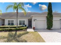 Inviting townhome showcasing well-manicured landscaping, paver driveway, and a charming covered entryway at 3201 Sonesta Ct # B, Clermont, FL 34711