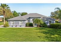 Charming single-story home featuring a well-manicured lawn, lush landscaping, and a welcoming facade at 3225 Site To See Ave, Eustis, FL 32726