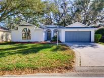 Charming one-story home with lush front yard and attached garage, perfect for suburban living at 3733 Plantation Blvd, Leesburg, FL 34748