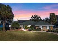 Charming single-story home boasts lush landscaping, brick accents, and a walkway leading to the front door at 37734 N County Road 44A, Eustis, FL 32736