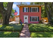 Charming two-story home with landscaped yard, brick walkway and front door with a wreath at 630 E 8Th Ave, Mount Dora, FL 32757