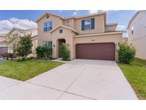 Charming two-story home featuring a well-manicured lawn and a spacious two-car garage at 7040 Oxbow Rd, Minneola, FL 34715