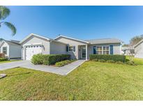 Charming single-story home with manicured lawn, beautiful landscaping, and attached two-car garage at 1100 Blythe Way, The Villages, FL 32162