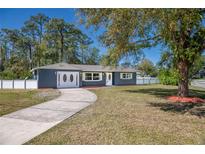 Charming home featuring a well-manicured lawn, long driveway, and inviting exterior at 16 General Doolittle Rd, Daytona Beach, FL 32124