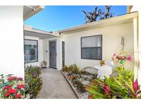 Inviting front entrance with a well manicured garden and table and chairs for comfortable outdoor seating at 2225 Cypress Ct # 2C, Tavares, FL 32778