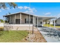 Charming single-story home featuring a carport, screened-in porch, and well-maintained landscaping at 27 Florence Blvd, Debary, FL 32713