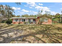 Charming single-story brick home featuring white shutters and a covered front porch on a large lot at 4107 Dove Valley Ln, Lady Lake, FL 32159