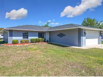 Charming single-story home featuring well-maintained lawn, manicured bushes, and a two car garage at 4857 Se 137Th Pl, Summerfield, FL 34491