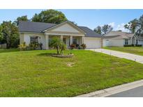 Well-maintained single Gathering home featuring a manicured lawn, garden bed, and neutral color palette at 513 Pine Lake View Dr, Davenport, FL 33837