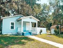 Charming single story home featuring a covered front porch, light blue paint and sidewalk with grass on either side at 728 Mckenzie St, Leesburg, FL 34748