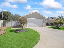 Charming single-story home features a well-manicured lawn and a two-car garage, enhancing its curb appeal at 1487 Gantt St, The Villages, FL 32162