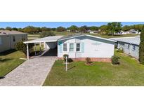 Charming single-story home with a well-manicured lawn, covered parking, and quaint curb appeal at 1510 E Schwartz Blvd, The Villages, FL 32159