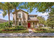 Charming two-story home with a bright red front door and a meticulously landscaped front yard at 15475 Camp Dubois Cres, Winter Garden, FL 34787