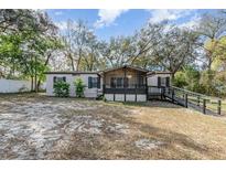 Charming home with light siding, black shutters, wheelchair ramp and a screened in porch at 1638 Leesburg Blvd, Fruitland Park, FL 34731