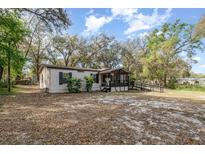 Quaint home featuring light siding, black shutters, screened porch and wheelchair ramp at 1638 Leesburg Blvd, Fruitland Park, FL 34731
