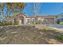 Charming single-story home with a well-manicured lawn and attached two-car garage at 181 Sutter Dr, Clermont, FL 34711