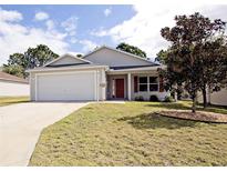 Charming single-story home with a well-manicured lawn, attached garage, and inviting curb appeal at 2082 Harston Trl, The Villages, FL 32162