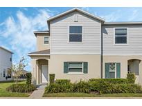 Charming two-story home featuring neutral siding, green shutters, and well-maintained front yard landscaping at 213 Primrose Dr, Davenport, FL 33837