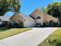 Charming single-Gathering home featuring a well-manicured lawn and a two-car garage with a spacious driveway at 2207 Black Hawk St, Clermont, FL 34714