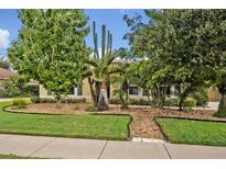 Well-manicured front yard with lush landscaping and a variety of trees and plants at 257 Winding Cove Ave, Apopka, FL 32703