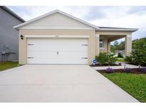 Charming single-story home featuring a two-car garage, well-maintained lawn, and manicured shrubbery at 412 Lady Bella Pl, Deland, FL 32724