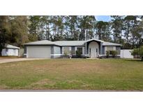 Charming single-story home with a manicured lawn, two-car garage, and inviting front entrance at 505 Hamlet Ct, Fruitland Park, FL 34731
