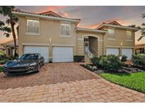 Charming Mediterranean-style townhouse with a brick driveway, two-car garage and well manicured landscaping at 5359 Compass Pt, Oxford, FL 34484