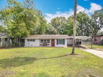 Charming one story home with a well manicured front lawn and a traditional red front door at 1108 Cedar St, Leesburg, FL 34748