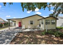 Inviting single-story home featuring a covered parking area and a cozy outdoor seating space at 1729 Lauren Ln, Lady Lake, FL 32159