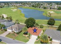 Stunning aerial view of a home on a golf course with a serene lake, surrounded by lush greenery and mature trees at 2068 Darlington Dr, The Villages, FL 32162