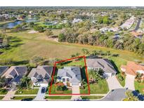 Beautiful home with a well-manicured lawn and landscaping, complemented by mature trees, near a lake at 27023 Old English Ct, Leesburg, FL 34748