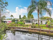 Charming waterfront home featuring a wooden bridge and lush landscaping under a beautiful blue sky at 3211 Myakka River Rd, Tavares, FL 32778